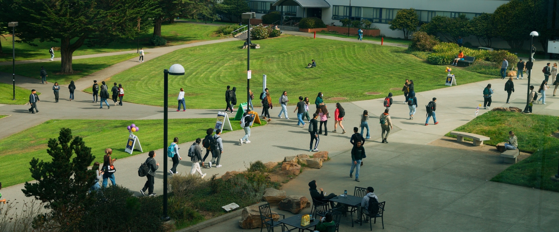 Ariel view of students walking on campus sidewalks next to green grass